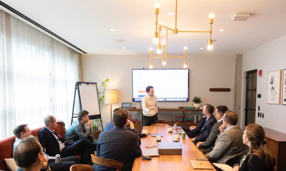 man talking to group of people in boardroom